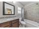 Bathroom features vanity with granite countertop, framed mirror, tiled shower and tub with decorative curtain, and modern fixtures at 2423 Rosapenna Nw Ln, Kennesaw, GA 30152