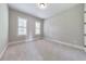 A quiet bedroom with neutral paint, carpet flooring, and a window bringing in plenty of natural light at 2423 Rosapenna Nw Ln, Kennesaw, GA 30152