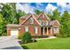 Beautiful two-story brick home with lush green lawn and manicured landscaping at 2423 Rosapenna Nw Ln, Kennesaw, GA 30152