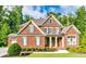 Charming brick home with a covered front porch and lush landscaping, offering great curb appeal at 2423 Rosapenna Nw Ln, Kennesaw, GA 30152