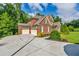 Charming brick home featuring a three-car garage and a spacious driveway at 2423 Rosapenna Nw Ln, Kennesaw, GA 30152