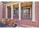 Charming brick front porch with wooden door and columns provides a welcoming entrance at 2423 Rosapenna Nw Ln, Kennesaw, GA 30152