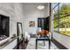 Well-lit office space with modern fireplace, built-in bookshelves, hardwood floors, and scenic outdoor views at 3184 Wood Valley Nw Rd, Atlanta, GA 30327