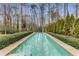Inviting pool surrounded by lush greenery and mature trees creates a serene backyard oasis at 3184 Wood Valley Nw Rd, Atlanta, GA 30327