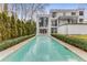 Modern home featuring a stunning pool, manicured hedges, and a wall of windows for natural light at 3184 Wood Valley Nw Rd, Atlanta, GA 30327