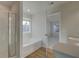 Bright bathroom featuring a separate shower and tub, complemented by wood-look flooring at 200 Sanctuary Dr, Mcdonough, GA 30253