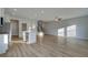 Open-concept living room with hardwood floors, modern lighting, and seamless flow into the kitchen and staircase at 200 Sanctuary Dr, Mcdonough, GA 30253
