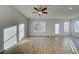 Bright living room with hardwood floors, ceiling fan, and natural light from multiple windows at 200 Sanctuary Dr, Mcdonough, GA 30253