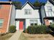 Charming townhome with a stucco facade, tidy landscaping, and a vibrant red front door at 3589 Main Station Sw Dr, Marietta, GA 30008