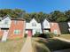 Well-maintained townhomes showcasing brick and stucco facades, accented by lush green lawns at 3589 Main Station Sw Dr, Marietta, GA 30008