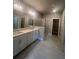 This primary bathroom has a double sink vanity, a glass shower, and tile floors at 273 Lakeside Pl, Canton, GA 30114