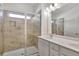 A bright bathroom featuring a double vanity with modern fixtures and a tiled walk-in shower with a glass enclosure at 1813 Hislop Ln, Atlanta, GA 30345