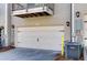 A two-car garage door with decorative hardware, flanked by exterior lighting and utilities in a residential setting at 1813 Hislop Ln, Atlanta, GA 30345