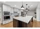 Modern kitchen featuring an island with seating, stainless steel appliances, pendant lights, and custom cabinetry at 3733 Doroco Dr, Atlanta, GA 30340