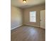 A bright bedroom with wood-look flooring and natural light from the window at 90 Hammock Dr, Covington, GA 30016