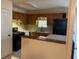 Kitchen with stainless steel sink, black appliances, wood cabinets and peninsula seating at 430 Poole Bridge Rd, Hiram, GA 30141