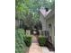 Stone pathway leads to a gated area with lush greenery and a house in the background at 6054 Nebo Rd, Hiram, GA 30141