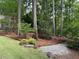 Backyard featuring landscaping with pine straw, trees, and a stone path at 6054 Nebo Rd, Hiram, GA 30141