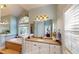 Spa-like bathroom featuring a soaking tub, separate shower, and dual vanities at 6054 Nebo Rd, Hiram, GA 30141