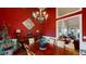 Traditional dining room with a buffet, striking red accent wall, chandelier, and seamless flow to the living area at 6054 Nebo Rd, Hiram, GA 30141