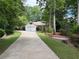 Long driveway leading to a home surrounded by lush greenery and mature trees, creating a private setting at 6054 Nebo Rd, Hiram, GA 30141