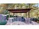 Covered outdoor kitchen featuring stone accents, countertops, and built-in appliances at 6054 Nebo Rd, Hiram, GA 30141