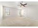 Spacious bedroom with neutral carpet, ceiling fan, vaulted ceiling, and large windows at 11948 Brightside Pkwy, Hampton, GA 30228