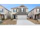 Two-story home showcasing neutral siding, complemented by a gray garage door and dark trim at 11948 Brightside Pkwy, Hampton, GA 30228
