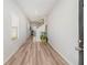 Hallway with light-colored wood floors leading to stairs and an open area, with a window to the left at 11948 Brightside Pkwy, Hampton, GA 30228