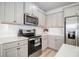 Close-up of a kitchen with white countertops, stainless steel appliances, and gray cabinets at 11948 Brightside Pkwy, Hampton, GA 30228