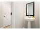 Stylish powder room features a pedestal sink with a black framed mirror and a white door at 11948 Brightside Pkwy, Hampton, GA 30228