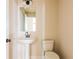 A modern powder room with a pedestal sink, square mirror, and neutral wall color at 735 Crossroad Sw Ct, Powder Springs, GA 30127