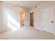 Bedroom features a light color scheme, plush carpet and an open doorway to a closet and bathroom at 735 Crossroad Sw Ct, Powder Springs, GA 30127