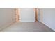 Neutral bedroom featuring carpet and two open doorways leading to the en-suite bathroom and closet at 735 Crossroad Sw Ct, Powder Springs, GA 30127