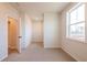Cozy bedroom with light carpet, a window overlooking trees and white painted walls at 735 Crossroad Sw Ct, Powder Springs, GA 30127