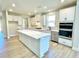 Open kitchen featuring a large island with quartz countertop, stainless steel appliances, and white cabinets at 735 Crossroad Sw Ct, Powder Springs, GA 30127