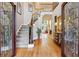 Grand foyer with hardwood floors, staircase, and decorative glass doors leading into the main living area at 1040 Avery Creek Dr, Woodstock, GA 30188