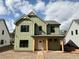 Charming two-story home featuring light-green vertical siding, black framed windows, and a welcoming covered front porch at 38 Puckett Se Rd, Emerson, GA 30137