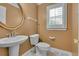 Cozy half bathroom with pedestal sink, gold framed mirror and natural light at 36 Latimer Nw Ln, Cartersville, GA 30121
