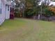 Large backyard with healthy green grass, wooden fence, and trees in the background at 6579 Alford Way, Lithonia, GA 30058