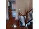 Hallway with wood floors leading to the kitchen with wooden cabinets and a staircase at 6579 Alford Way, Lithonia, GA 30058