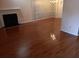 Spacious living room with a fireplace, gleaming hardwood floors, and natural light at 6579 Alford Way, Lithonia, GA 30058