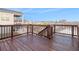 Spacious back deck with dark brown wood and railings, overlooking neighboring homes and trees against a bright blue sky at 5810 Collier Bridge Ln, Hoschton, GA 30548