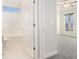 Bathroom doorway with a glimpse of a tub/shower combo and neutral tile flooring at 5810 Collier Bridge Ln, Hoschton, GA 30548