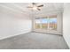 Spacious main bedroom with plush carpeting, tray ceiling, and three large windows at 5810 Collier Bridge Ln, Hoschton, GA 30548