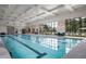 Indoor community pool featuring a tiled deck, large windows, and comfortable seating for residents to relax at 5810 Collier Bridge Ln, Hoschton, GA 30548