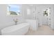 Bathroom featuring a modern freestanding tub with walk-in shower and white tile surround at 509 Pearl St, Cumming, GA 30040