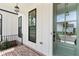 Inviting porch view with a green front door, brick flooring, and modern lighting at 509 Pearl St, Cumming, GA 30040