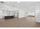 Open-concept living space features modern kitchen, hardwood floors, recessed lighting, and sliding glass doors to patio at 509 Pearl St, Cumming, GA 30040