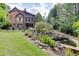 Serene backyard oasis with a waterfall, pond, and lush landscaping at 879 Big Horn Hollow, Suwanee, GA 30024